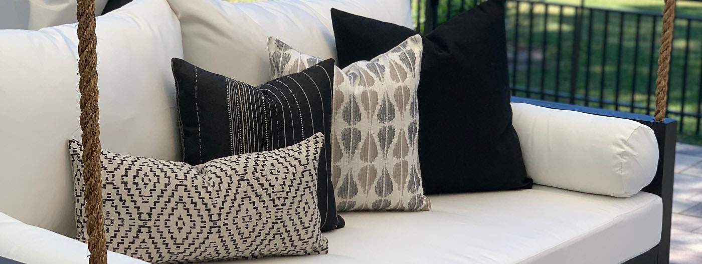 Sunbrella throw pillows styled on an outdoor swing bed